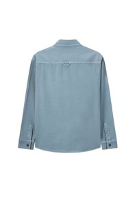 Chemise à manches longues bleu clair en tissu doux. Dispose d'un col, de poignets à boutons et d'un détail de boucle à l'arrière. Texture lisse avec des coutures subtiles.