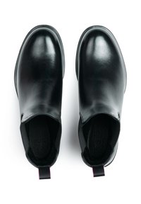 Chaussures en cuir noir avec une finition lisse, bout rond, panneaux latéraux élastiques et languette contrastante au talon.