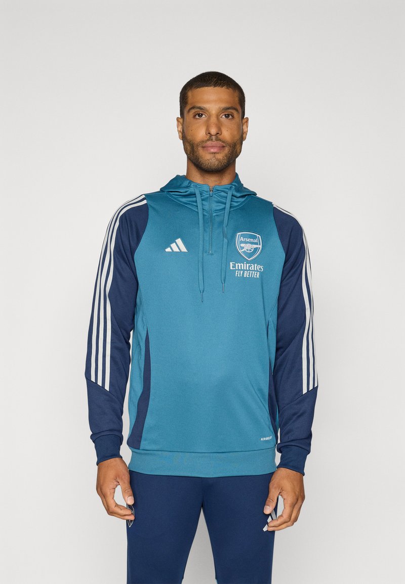 Teal hoodie with navy sleeves, featuring white Adidas stripes and an Arsenal logo. Soft fabric, zip fastening, and front pockets for utility.
