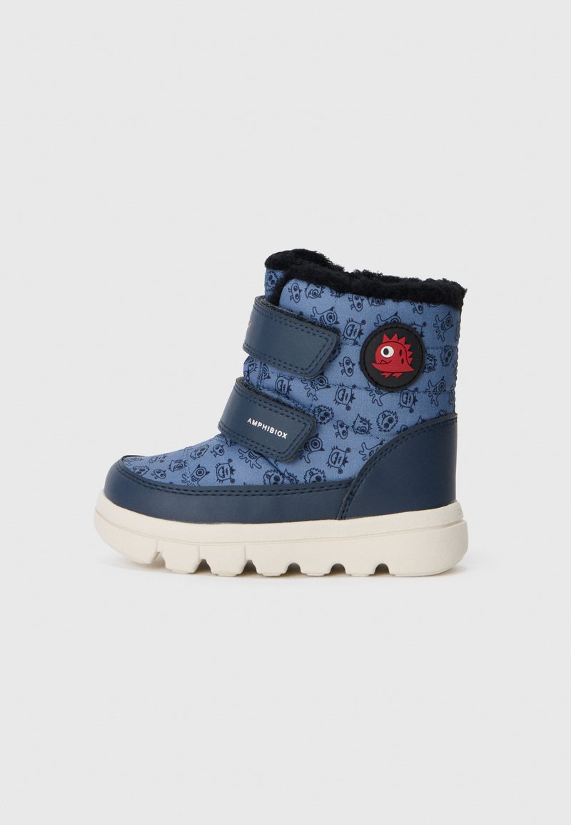 Granatowobłękitny wodoodporny but z wzorzystą cholewką, dwoma paskami na rzep, miękkim czarnym futrzanym wykończeniem i czerwoną rybą jako logo po boku.