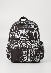 Juodas kuprinės modelis su baltais graffiti stiliaus raštais. Su viršutine rankena, reguliuojamomis diržais ir priekyje esančia užtrauktuku kišenė. Patvari medžiaga.