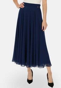 Granatowa plisowana spódnica midi wykonana z lekkiego materiału, z gładkim pasem w talii i zwiewnym dołem, tworzącym elegancką sylwetkę.