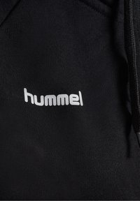 Sweat-shirt noir avec un logo "hummel" blanc, confectionné dans un tissu lisse au toucher doux, doté d'un cordon de serrage ajustable à la capuche.