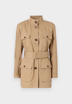 Tan utility jacket featuring a stand collar, two chest pockets with button flaps, and a belted waist. Made from lightweight fabric.
