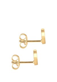 Pendientes de oro en forma de studs que presentan una base circular lisa y plana, así como un cierre decorativo en forma de bucle para un ajuste seguro. Diseño simple y elegante.