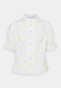 Blouse blanche à manches bouffantes courtes, avec une bordure en dentelle décorative, un imprimé floral jaune et des boutons sur le devant. Détail de l'ourlet froncé.