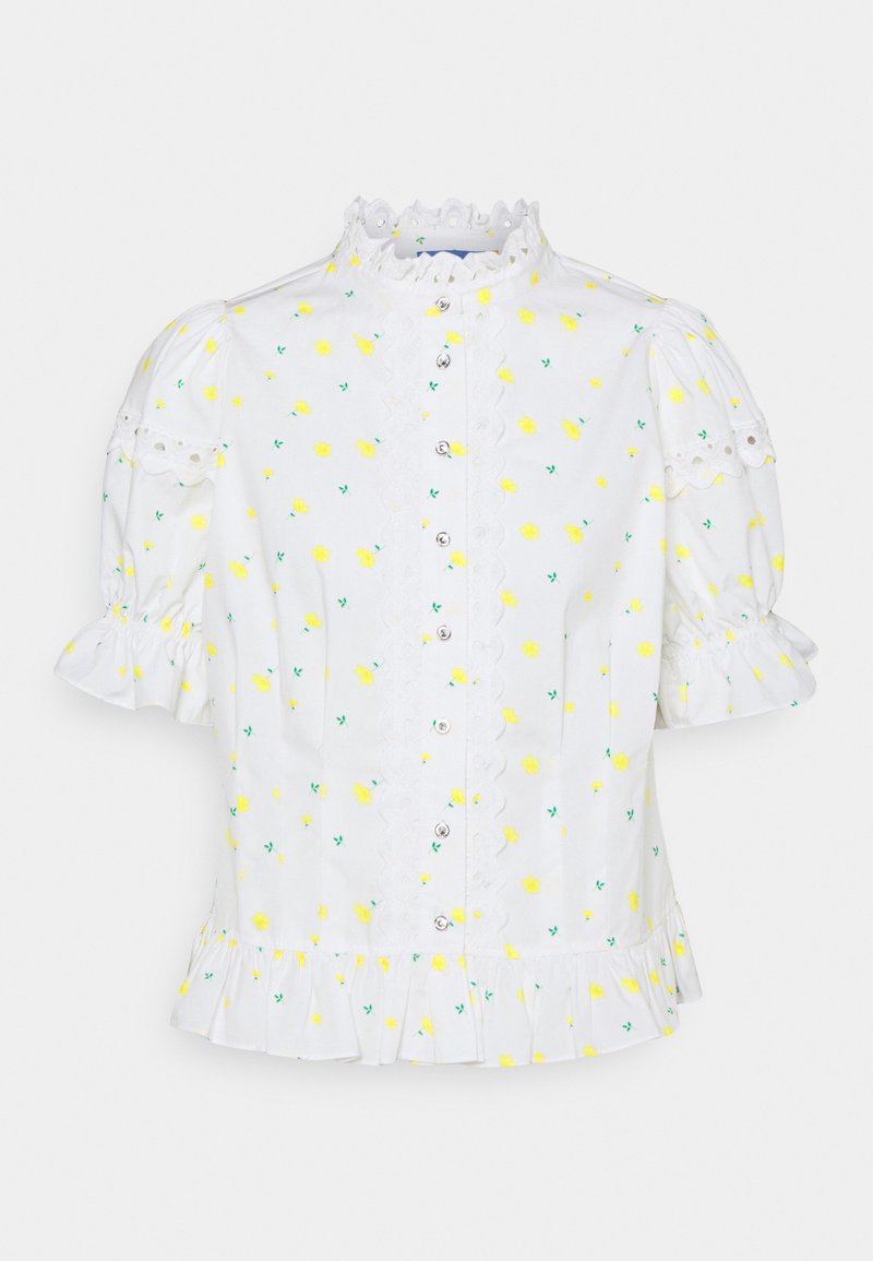 Blouse blanche à manches bouffantes courtes, avec une bordure en dentelle décorative, un imprimé floral jaune et des boutons sur le devant. Détail de l'ourlet froncé.