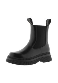 Botas de tobillo negras hechas de material sintético liso, con paneles laterales elásticos y una suela de goma gruesa texturizada con tiradores.