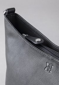 Black leather pouch with a textured surface, featuring a silver zipper and embossed logo on the side.