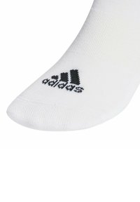 Biała skarpetka sportowa wykonana z gładkiego materiału o prążkowanej fakturze. Zawiera czarne logo Adidasa na górze.