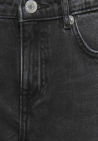 Melnas denima bikses ar klasisko piecu kabatu dizainu, sudraba aksesuāriem, smalku tekstūru un tonālas uzšūšanas detaļām.