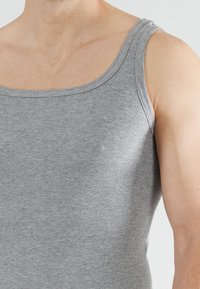 Grijze geribbelde tanktop met brede schouderbanden en een ronde halslijn, met een aansluitend ontwerp en een zachte textuur.