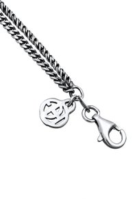 Silverfärgad metallkedja med snodda länkar, som har en cirkulär berlock och en hummerlås för fastsättning. Graverad detalj på berlocken.