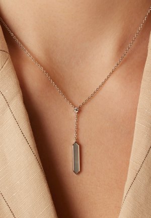 Zilveren ketting met een rechthoekige hanger met een gladde, reflecterende oppervlakte, hangend aan een delicate kralenlink.