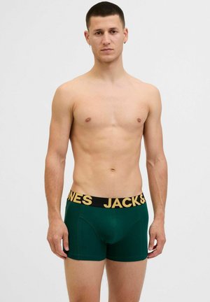 Gröna kalsonger med svart midjeband som har gul text med "JACK & JONES". Slät tyg och åtsittande design.