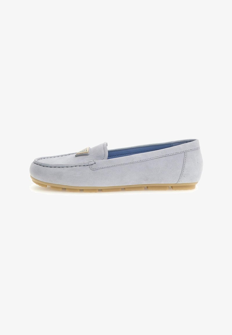 Lysegrå ruskind slip-on loafer med tan gummisål og trekantet metalisk logodetalje på toppen, set fra siden på hvid baggrund.