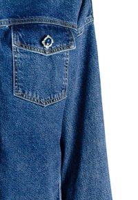 Camicia in denim con taschino decorato da un accento di gemma blu. Materiale texturizzato, di un profondo colore blu, con cuciture in contrasto.