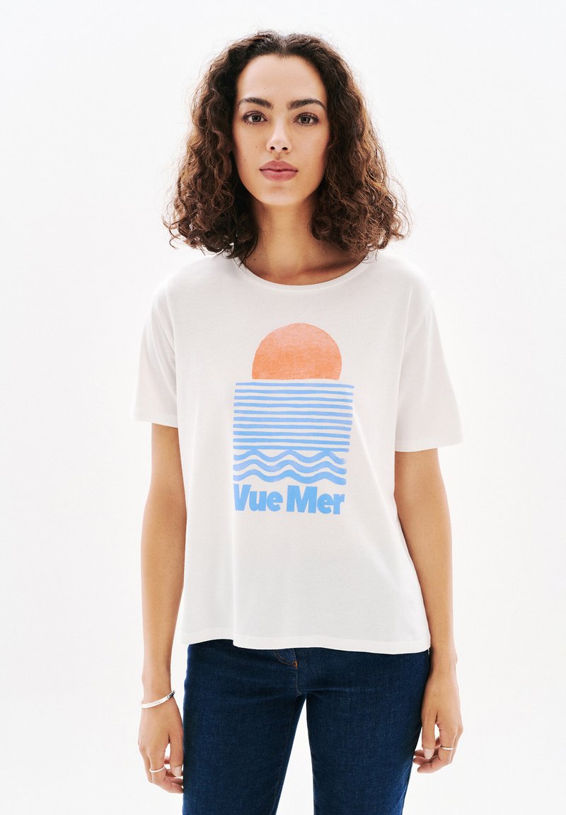 Camiseta de algodón blanca con un diseño gráfico de un sol naranja y olas azules, con el texto "Vue Mer" impreso debajo en azul.