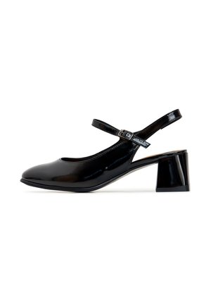 Zapato negro de charol con tirante trasero, punta redonda y tacón cuadrado de altura media. Presenta una correa ajustable en el tobillo con hebilla.