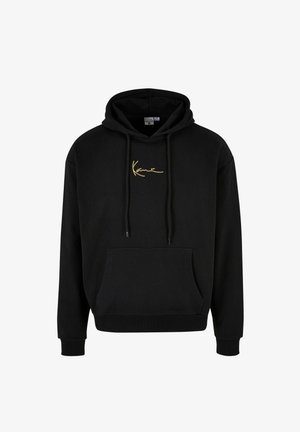 Černá mikina s kapucí, přední kapsou, stahovacími šňůrkami a malým zlatým nápisem uprostřed na hrudi.