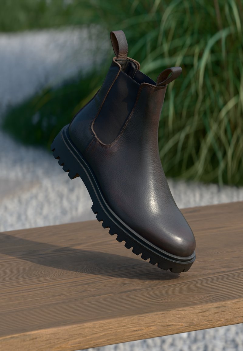 Brune lær Chelsea-støvlett med elastiske sidepaneler, teksturert finish og robust svart gummisåle. Distinktiv løftesløyfe bak.