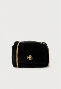 Černá kabelka z umělé kožešiny se zlatým řetízkovým páskem, obdélníkového tvaru, s magnetickým zapínáním na klopu a logem na přední straně.