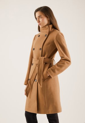 Manteau camel croisé en tissu doux, avec un col haut, une taille ceinturée, de grands boutons noirs et des poches latérales.