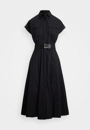 Svart bomullsskjortekjole med belte i midjen, korte ermer, to brystlommer og en utsvakt skjørt. Glatt tekstur, skreddersydd design.