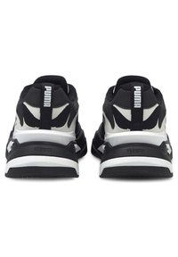 Ein Paar schwarze und weiße Puma-Sneaker, von hinten gezeigt, mit markanten schwarzen Streifen und "Puma"-Logo auf der Ferse.