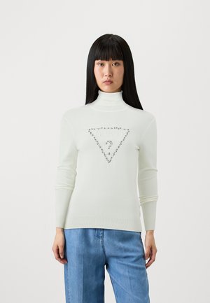 Maglione bianco a collo alto realizzato in morbido tessuto a maglia, decorato con un logo triangolare ornato di strass sul petto. Maniche lunghe; orlo a costine.