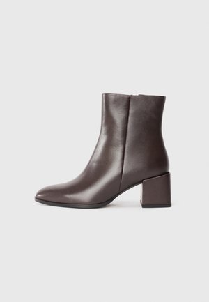 Brown leather ankle boot with a sleek design, pointed toe, and square block heel. Smooth texture and minimalistic silhouette.