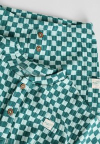 Groen en lichtblauw geruit shirt en broekset, met houten knopen, een ronde halslijn en een gestikt label met tekst.