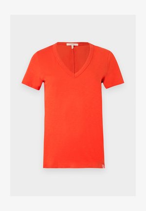 Φωτεινή πορτοκαλί βαμβακερή κοντομάνικη μπλούζα με βαθύ V-λαιμό και μικρή ετικέτα μάρκας στο κάτω μέρος της ραφής σε λευκό φόντο.
