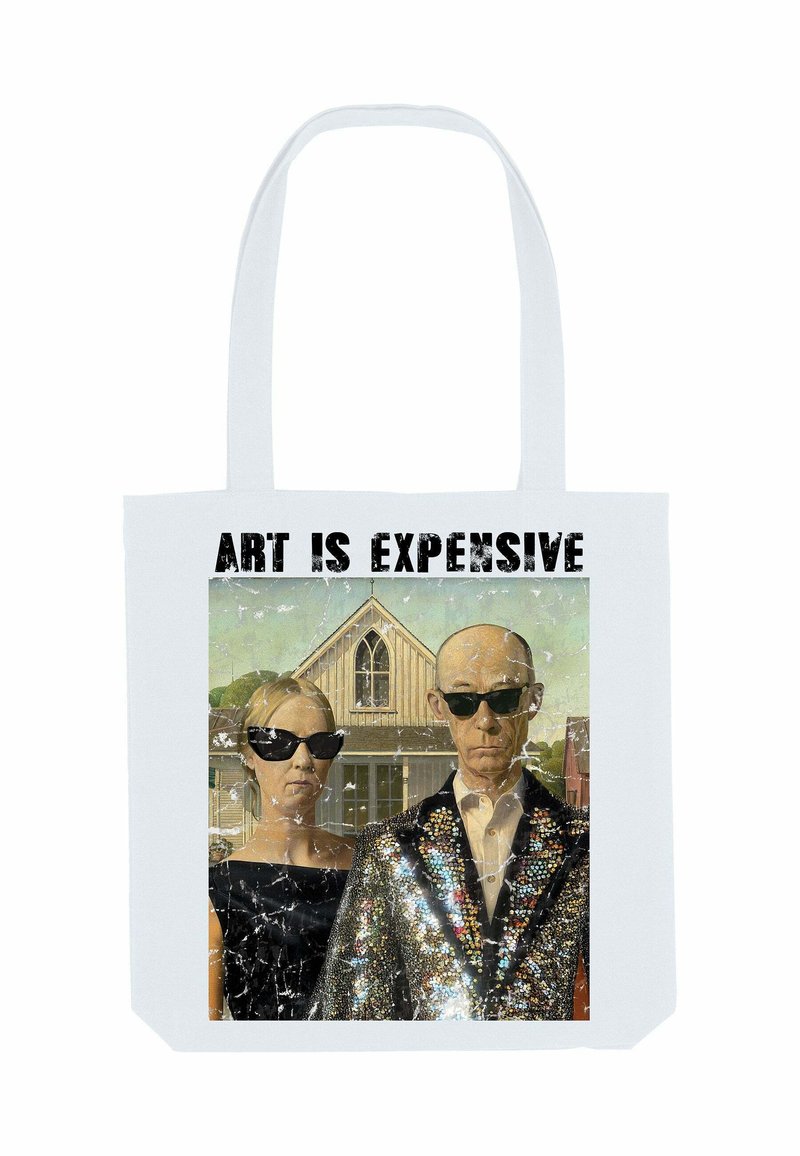 Twee personen met zwarte zonnebrillen en formele kleding staan voor een boerderij met de tekst "KUNST IS DUUR" boven hen.