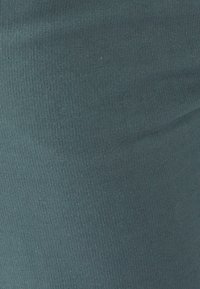 Geribbeld teal stof, met een gladde textuur en gelijkmatige gestreepte breedte, die een uniforme kleur laat zien zonder zichtbare patronen of hardware.