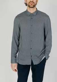 Camicia button-up di colore blu scuro con motivo geometrico, maniche lunghe, colletto abbottonato e vestibilità slim. Realizzata in tessuto leggero.