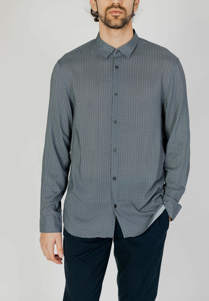 Camicia button-up di colore blu scuro con motivo geometrico, maniche lunghe, colletto abbottonato e vestibilità slim. Realizzata in tessuto leggero.