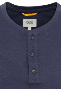 Granatowa koszula henley wykonana z teksturowanej tkaniny, z trzema guzikami, zaokrąglonym dekoltem i pomarańczowym akcentem wewnątrz kołnierza.