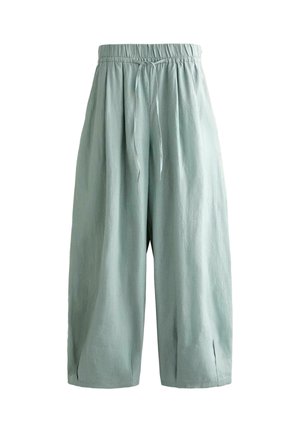 Pantalon ample vert clair à jambes larges avec taille élastique et cordon à l'avant, présentant de petites fentes à l'ourlet.
