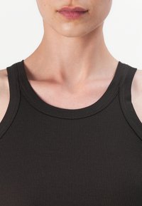 Czarny prążkowany top na ramiączkach z okrągłym dekoltem i szerokimi ramiączkami, prezentujący gładki, teksturowany materiał.