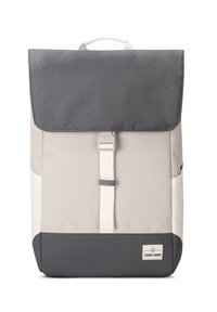 Backpack in beige and gray tones, featuring a flap closure, white strap, and a small logo tag at the bottom. Textured material and structured shape.