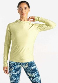 Hellgrüner Langarm-Hoodie mit einer vorderen Tasche und Kapuze, kombiniert mit blau-gelben Leggings, die mit abstrakten Farbspritzdesigns gemustert sind.