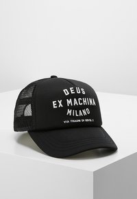Cappellino nero con una parte frontale solida, retro in rete e testo bianco che recita "DEUS EX MACHINA MILANO" e "VIA THAON DI REVEL 3" sulla parte anteriore.