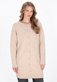 Beige gestrickte Strickjacke mit rundem Ausschnitt, langen Ärmeln und dekorativen Knöpfen. Weiche Textur mit geripptem Saum.