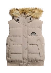 Beige Puffer-Weste mit einer Kapuze mit Fellbesatz, Druckknopfverschluss, seitlichen Taschen und einem Logo-Patch auf der Brust. Weicher, gesteppten Außenstoff.