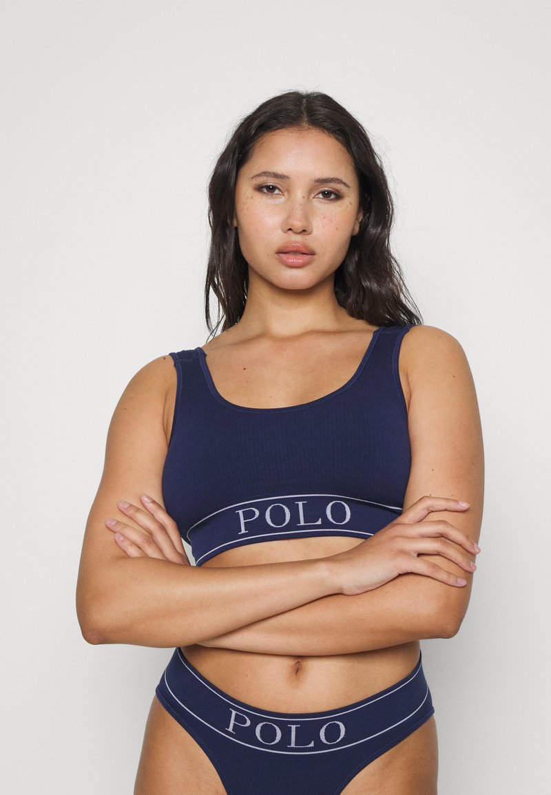 Tumši zila ribota kokvilnas bralete un saskaņota augstās jostasvietas bikini, kas rotāta ar kontrastējošu logotipa joslu ap jostasvietu. Gluda tekstūra.