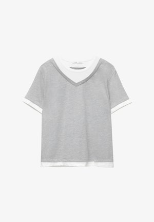 Top a maniche corte di colore grigio chiaro sovrapposto a una maglietta bianca a girocollo con bordi bianchi abbinati sulle maniche e sull'orlo.