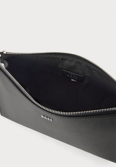 Pochette noire zippée avec logo BOSS argenté sur le devant et doublure intérieure noire, présentée ouverte en angle sur fond blanc.