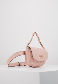 Mała pikowana różowa skórzana torebka na ramię z złotym łańcuszkiem i regulowanym paskiem, logo "Guess" na przedniej klapce.