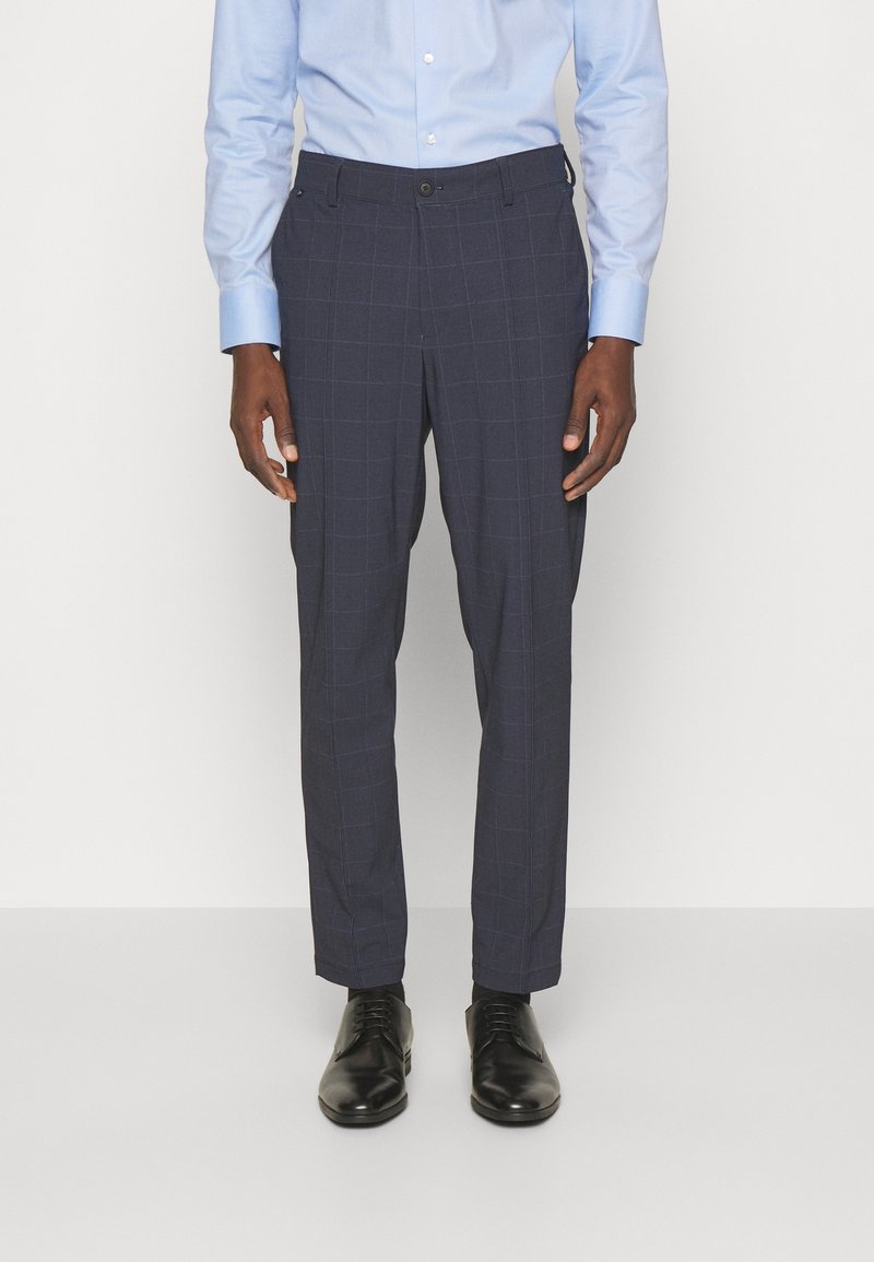Navy checkered trousers made of fabric with a smooth texture, featuring a tailored fit, belt loops, and a button closure. Paired with black shoes.